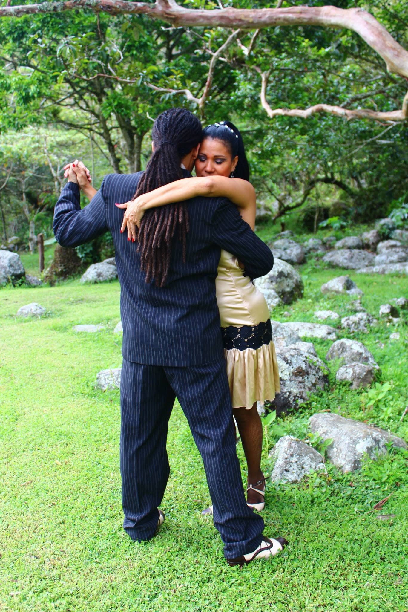 Alexis Andrade bailando tango al aire libre en un jardín