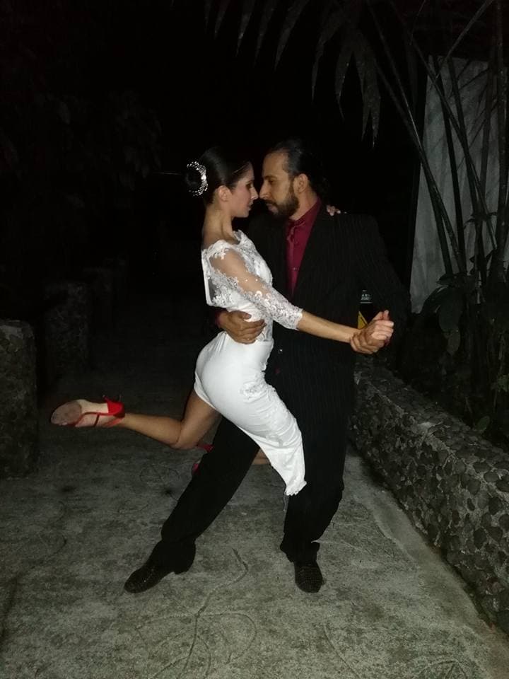 Retrato de Alexis Andrade con su pareja de baile, plumas rojas