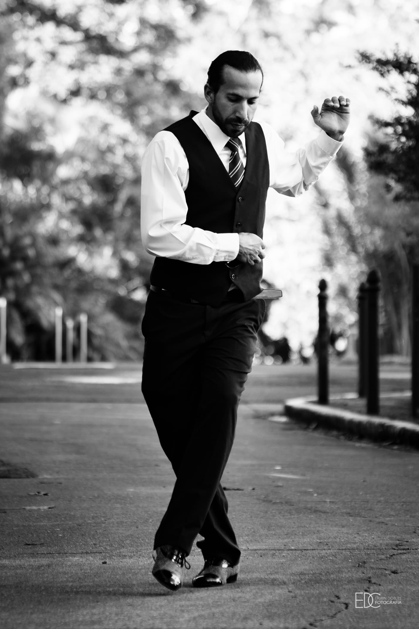 Alexis Andrade, bailarín e instructor de tango, caminando en pose de tango al aire libre