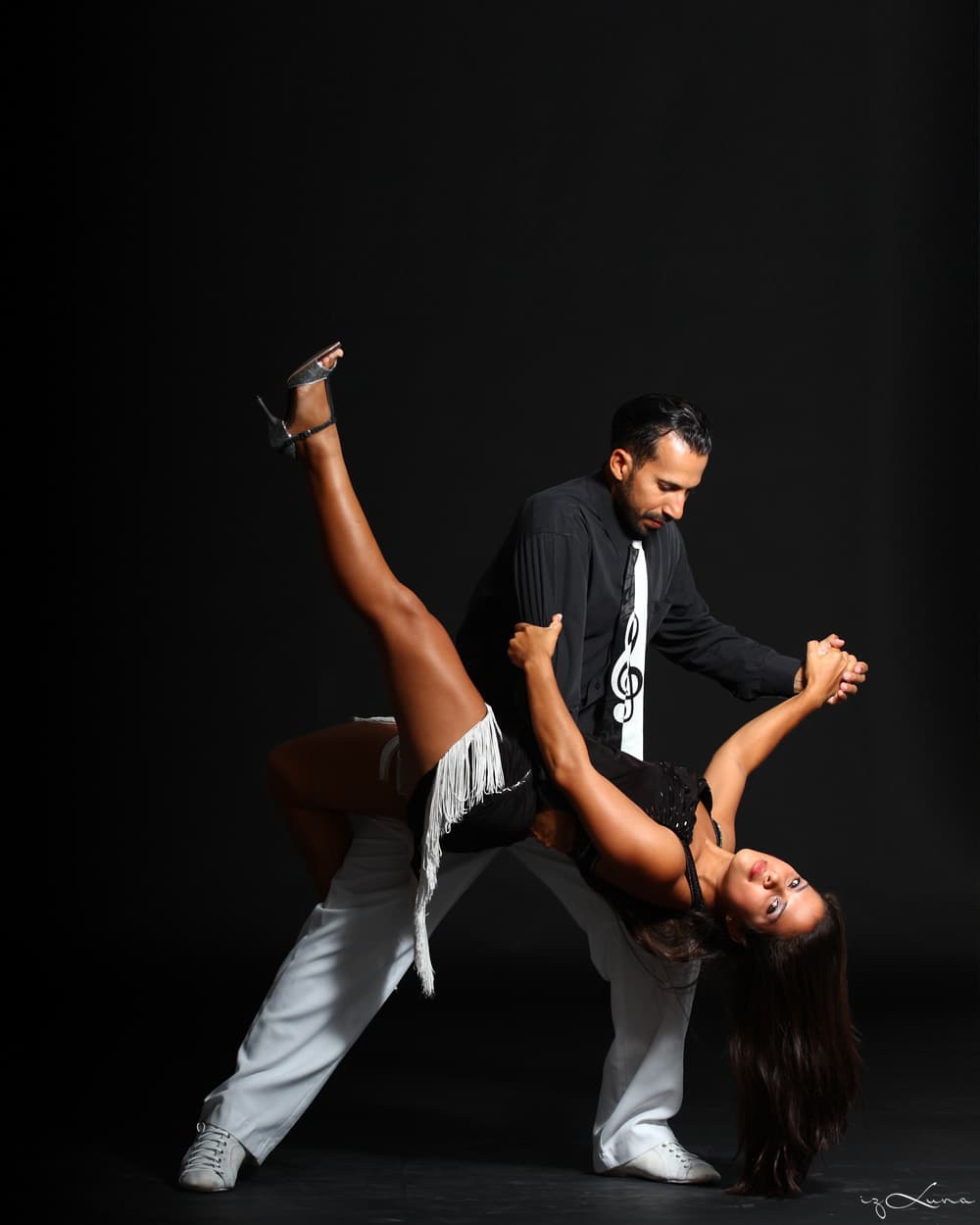 Pareja practicando una figura de tango durante una clase privada