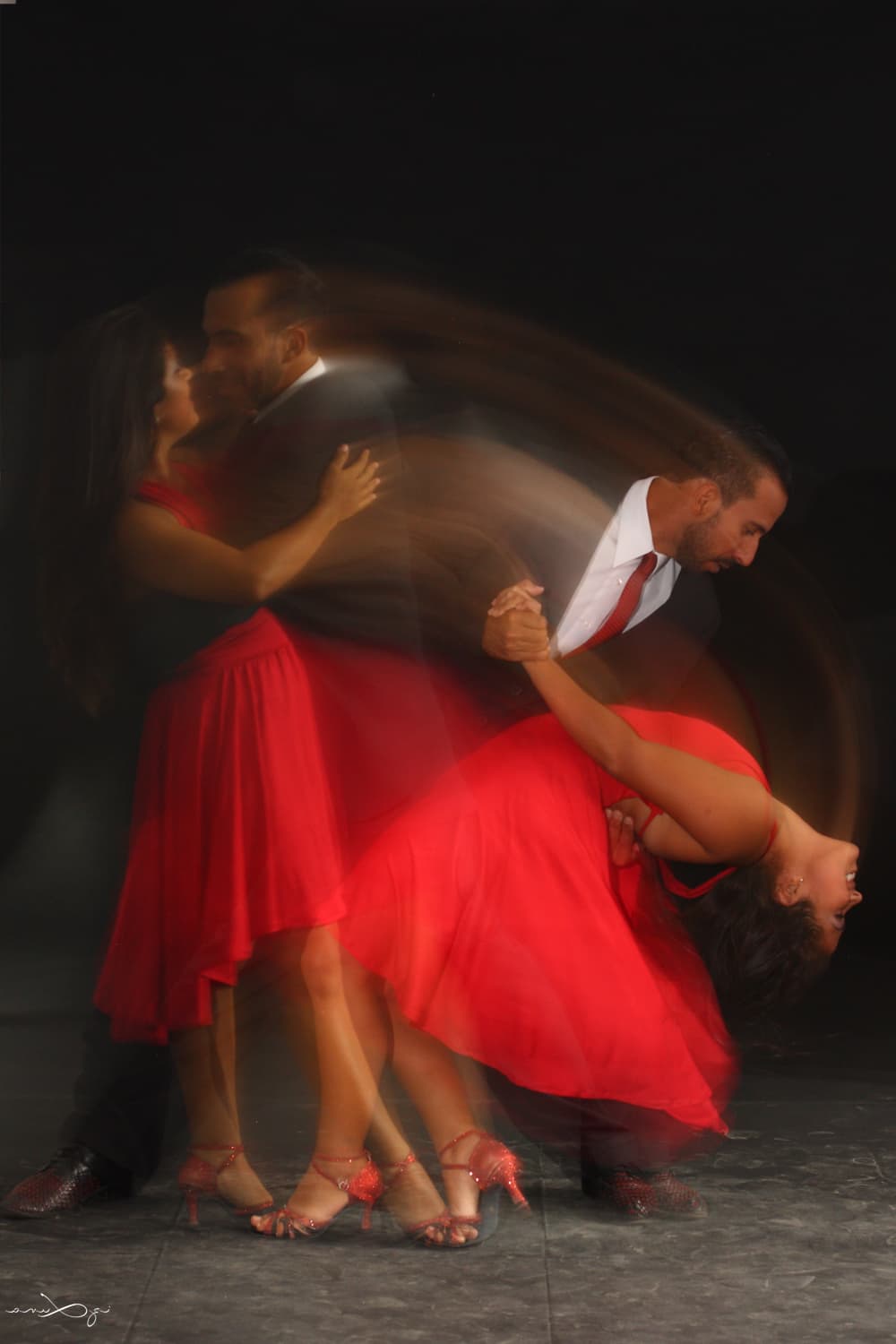 Tango Partner realizando una figura de baile en una milonga con vestido rojo